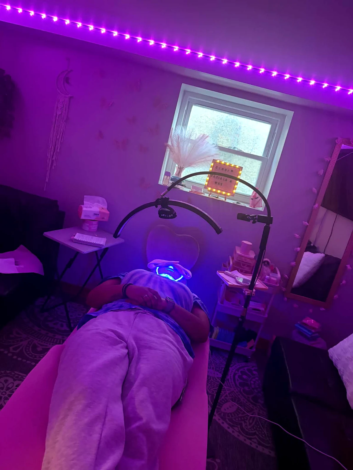 Facial treatment setup with purple studio lighting