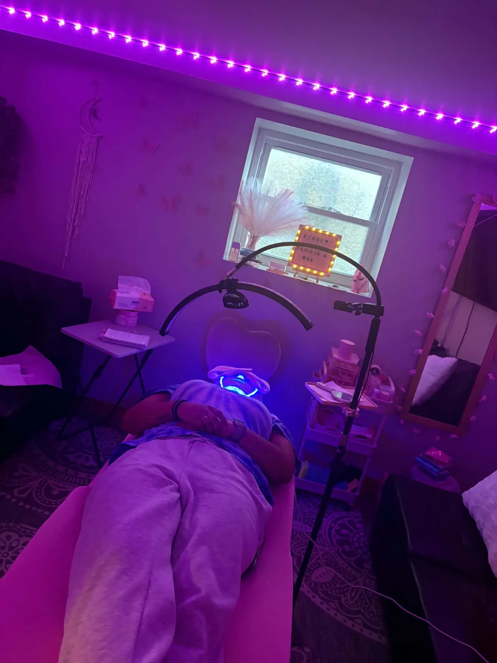Facial treatment setup with purple studio lighting